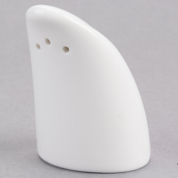 A white salt shaker with three holes.