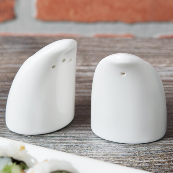 A white Royal Rideau porcelain salt shaker on a wood table.