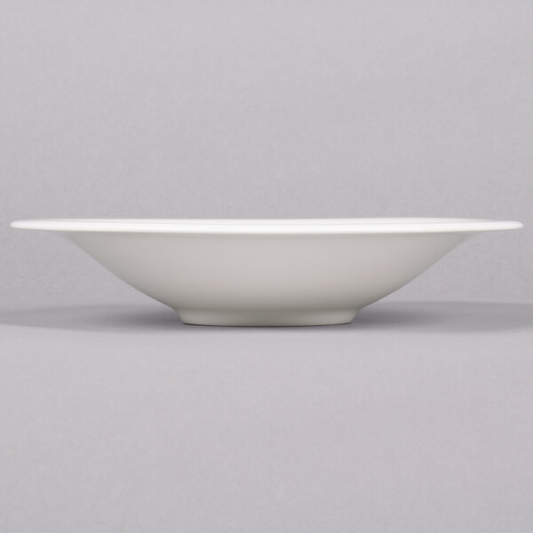 A white Reserve by Libbey Silk porcelain coupe bowl on a gray surface.