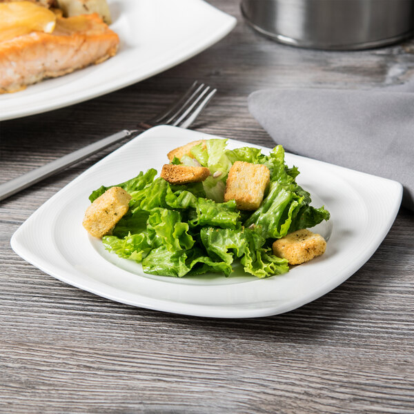 A Reserve by Libbey Royal Rideau white porcelain plate with salad, chicken, and vegetables on it.