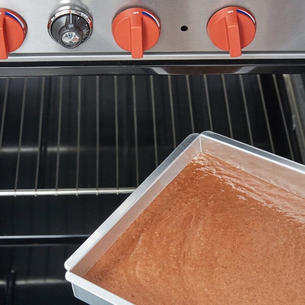 An Ateco rectangular cake pan with brown liquid baking in it.