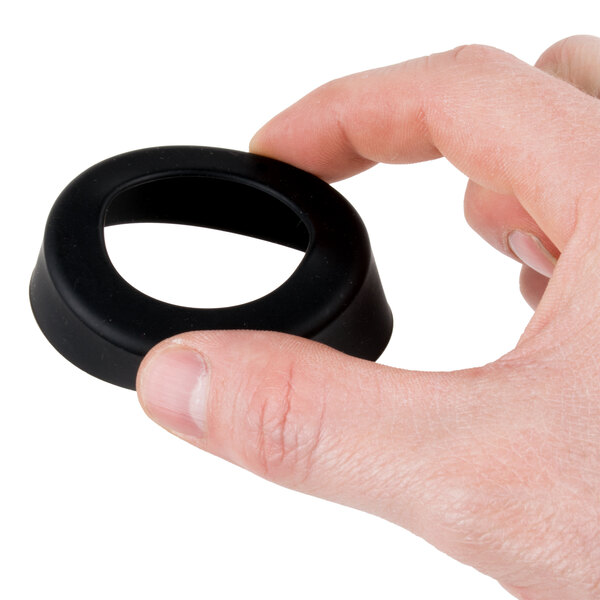 A hand holding a black silicone round object.
