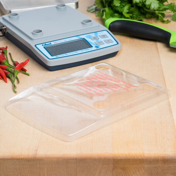 A ClearShield plastic cover on a scale with vegetables in a plastic bag.