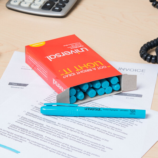 A box of Universal blue chisel tip highlighters on a desk with a pen.