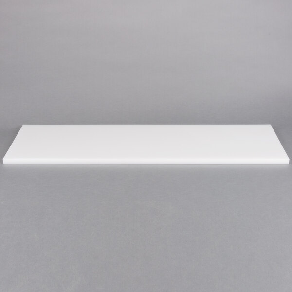 A white rectangular cutting board on a gray surface.