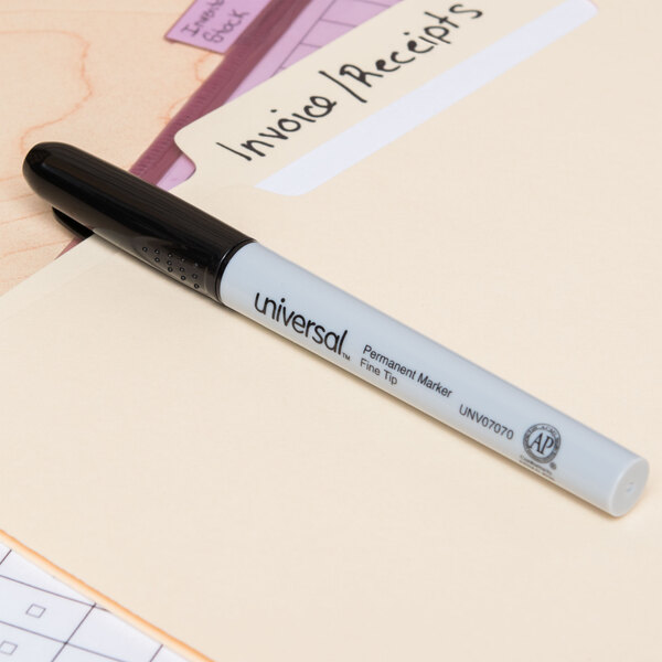 A Universal black bullet tip permanent marker writing on a file folder.