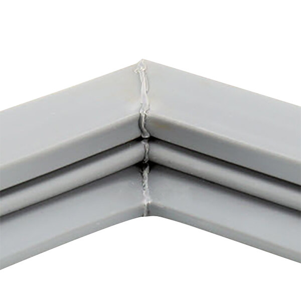 A close up of a gray corner piece of a Traulsen magnetic door gasket.