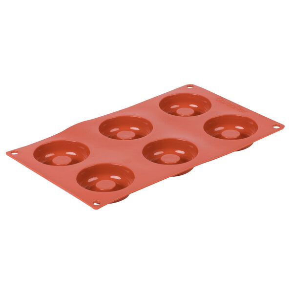 A red silicone baking pan with six holes.