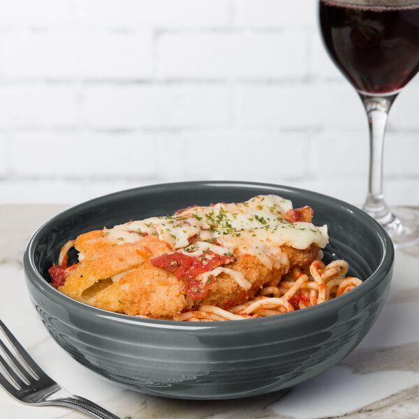 A bowl of spaghetti and a glass of wine served in a Fiesta Slate Medium Bistro Bowl with a fork.