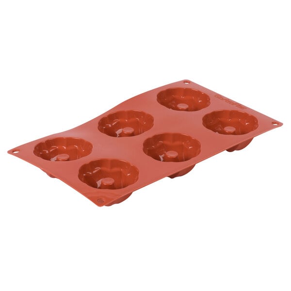 A red silicone cake pan with six Kugelhopf molds.
