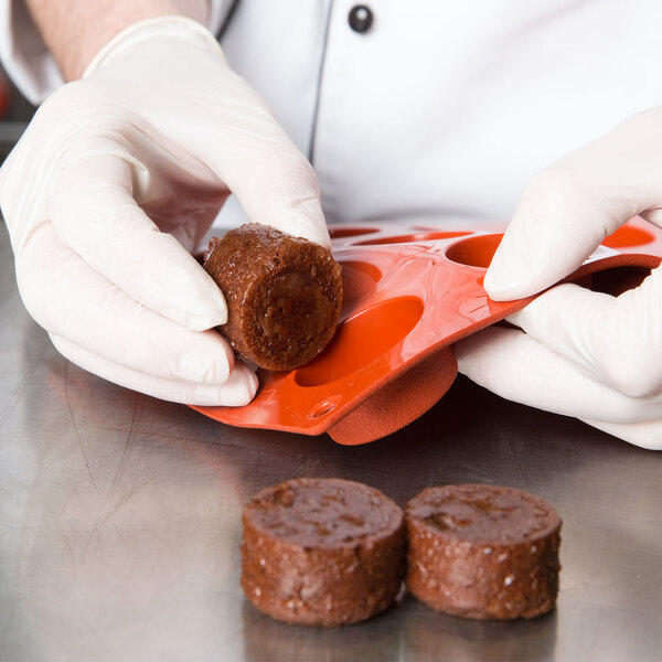 A person in gloves holding a round brown Matfer Bourgeat mold.