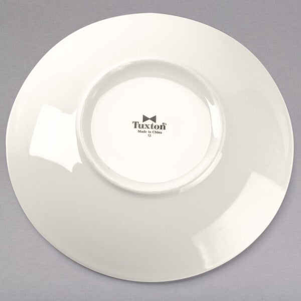A white Tuxton pasta/salad bowl with a black rim and black text on it.