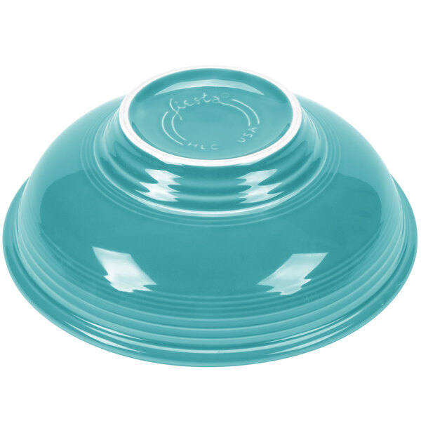 A turquoise bowl with a white rim.