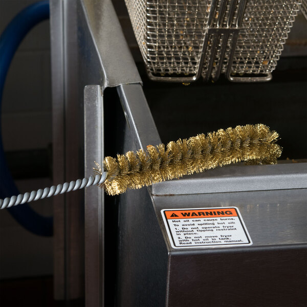 A Chef Master L-shaped fryer brush with brass bristles.