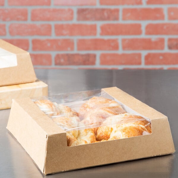 A Kraft bakery box filled with pastries on a table.