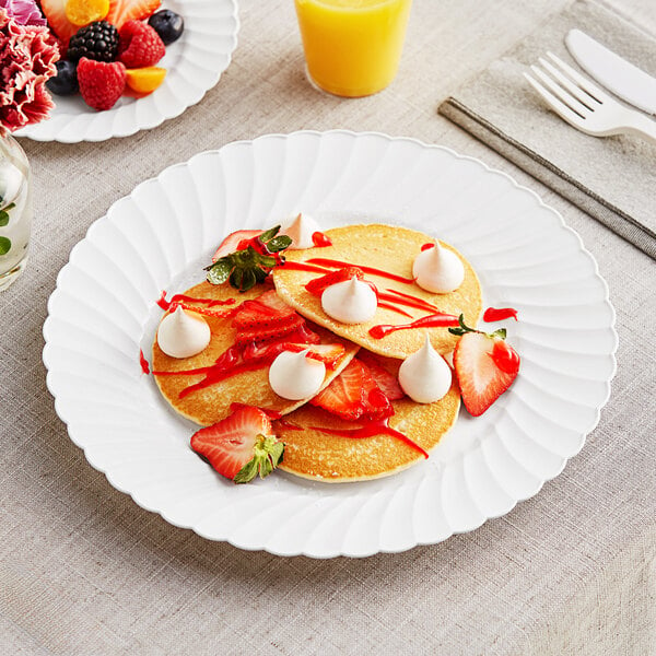 A stack of pancakes on a white WNA Comet plastic plate with strawberries and whipped cream on top.