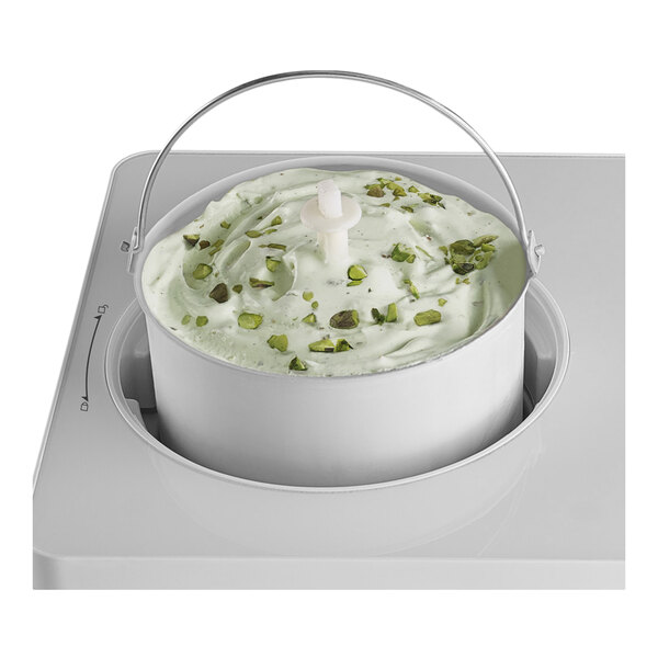 An ice cream paddle attachment in a machine, shown with pistachio ice cream.