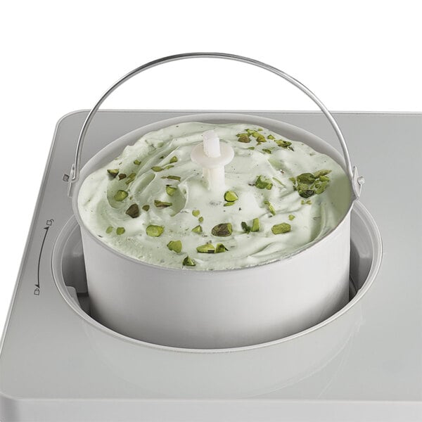 A white Waring batch bowl with green ice cream in it.