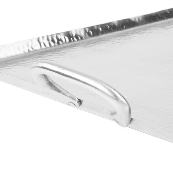 A close-up of the handle of an American Metalcraft large rectangular stainless steel griddle.