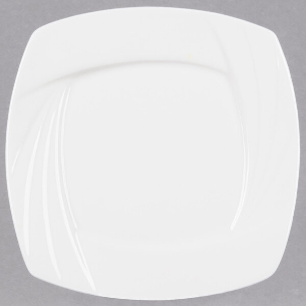 A close-up of a CAC Garden State white square porcelain plate with a curved edge.