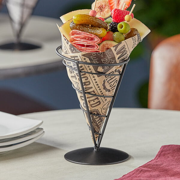 A black cone-shaped container from Tablecraft with food inside on a table.