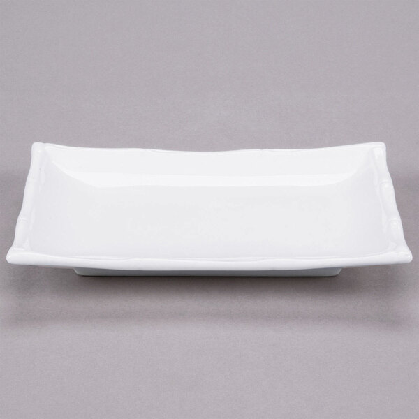 A bright white rectangular porcelain platter with a bamboo pattern.