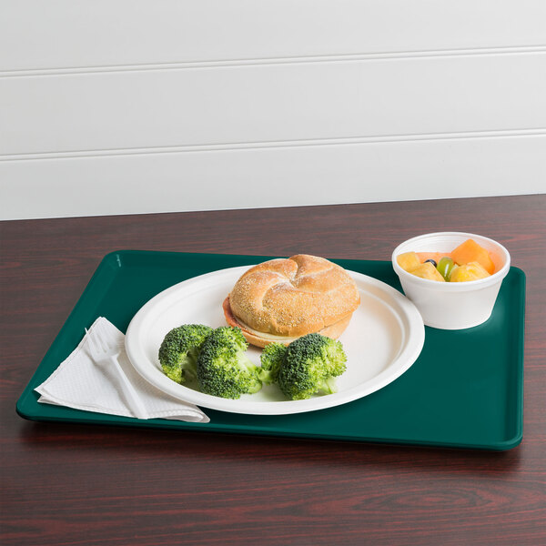 A teal Cambro dietary tray with broccoli, bread, and a drink on it.