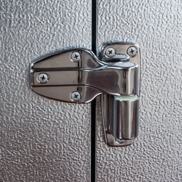 A close-up view of a metal hinge on the door of a Norlake Kold Locker outdoor walk-in freezer.
