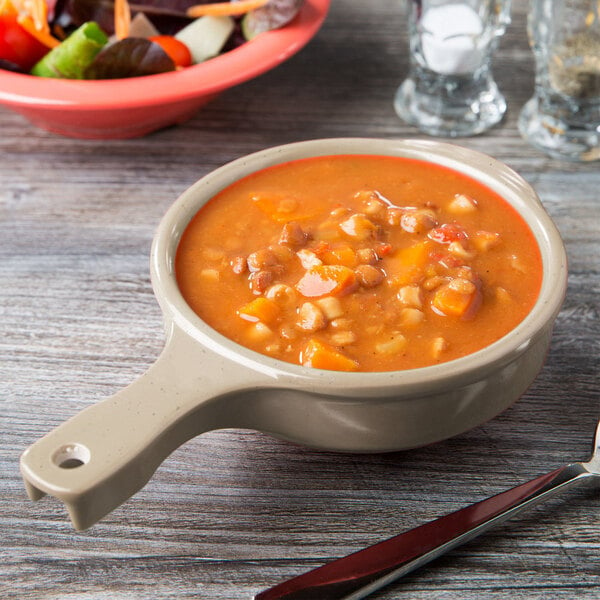 A GET Tahoe Sandstone bowl filled with soup on a table.