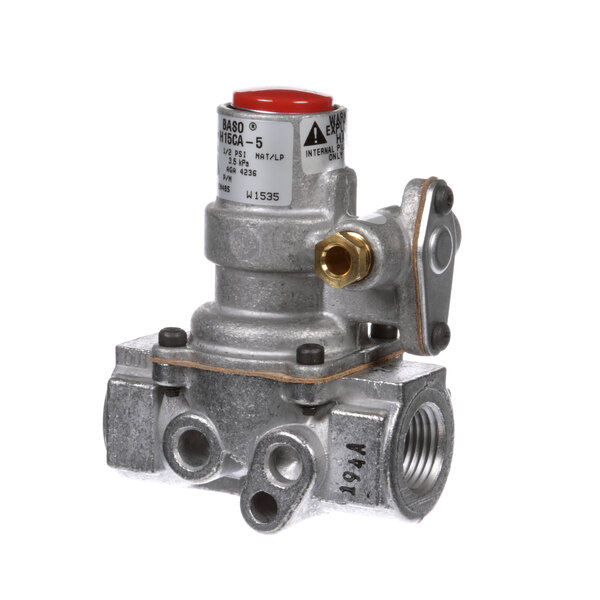 A close-up of a Star gas safety valve with a red button.