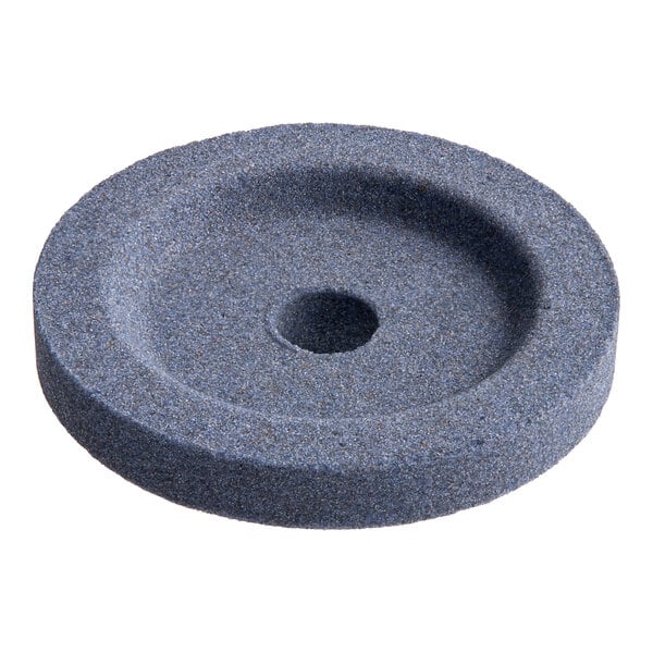 A grey circular stone with a hole in it.