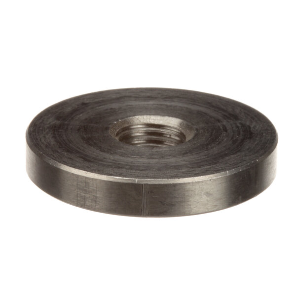 A close-up of a round black steel Champion nut with a hole in it.