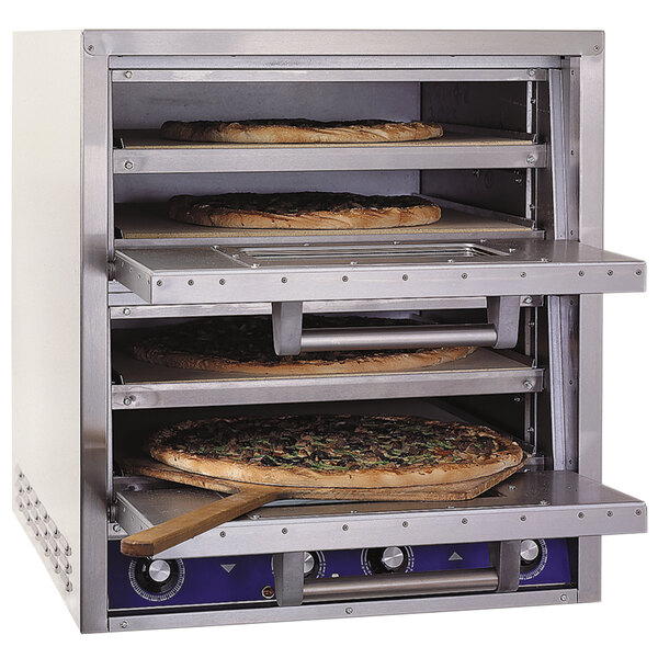 Three pizzas baking in a Bakers Pride countertop oven.