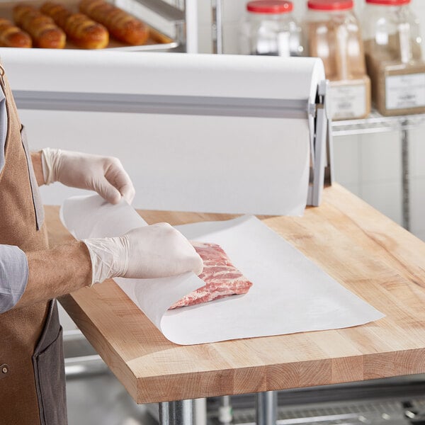 A person wearing gloves wrapping a piece of meat in Choice white freezer paper.