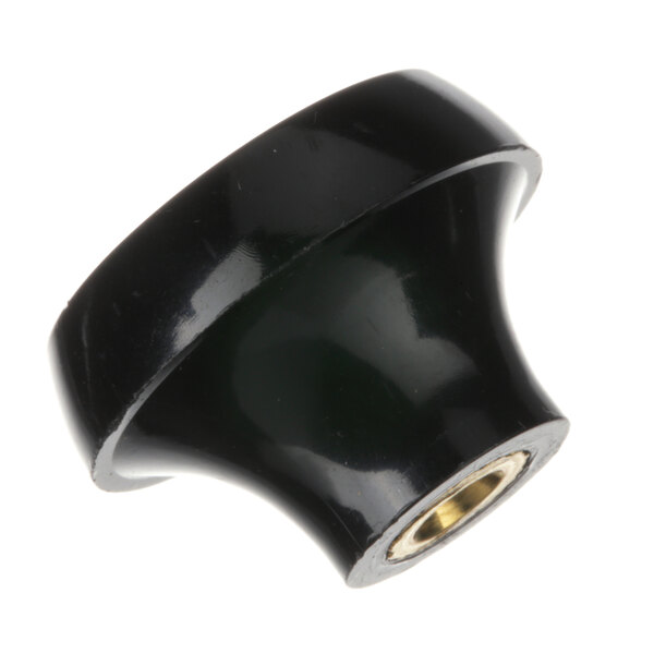 A black round knob with a gold center.