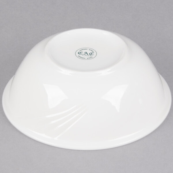 A white CAC porcelain bowl with a logo on it.