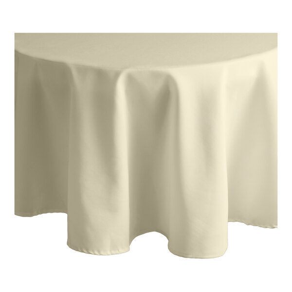 A white Intedge round tablecloth on a round table.