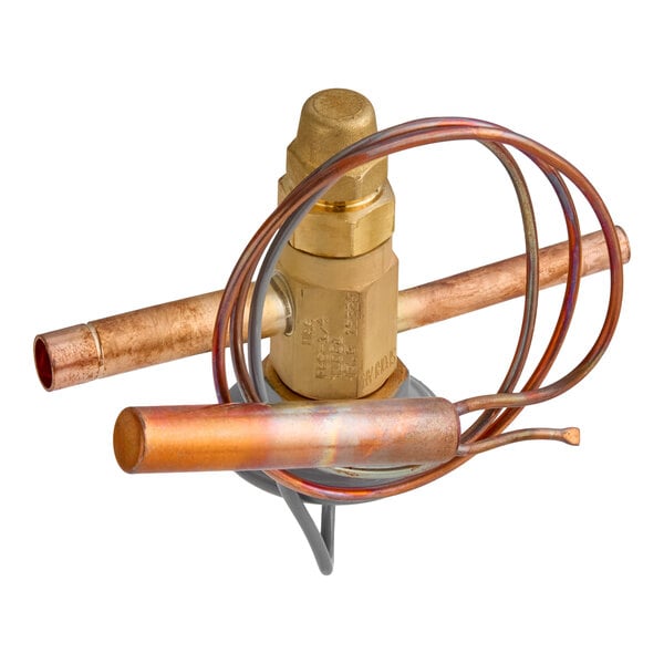 A brass and copper valve assembly with coiled tubing and cylindrical components, likely used in refrigeration or HVAC systems.