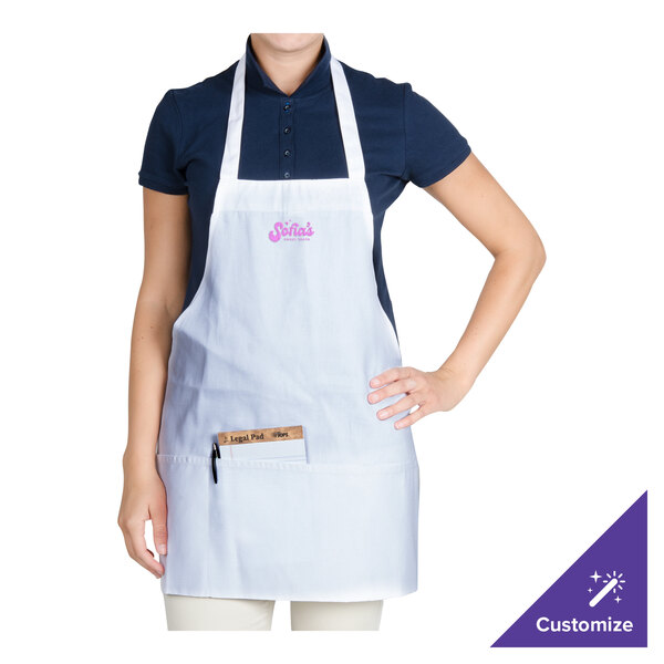 A woman wearing a white Chef Revival apron with pink writing.