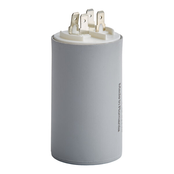 A cylindrical gray component with four metal prongs on top and a label on the side.