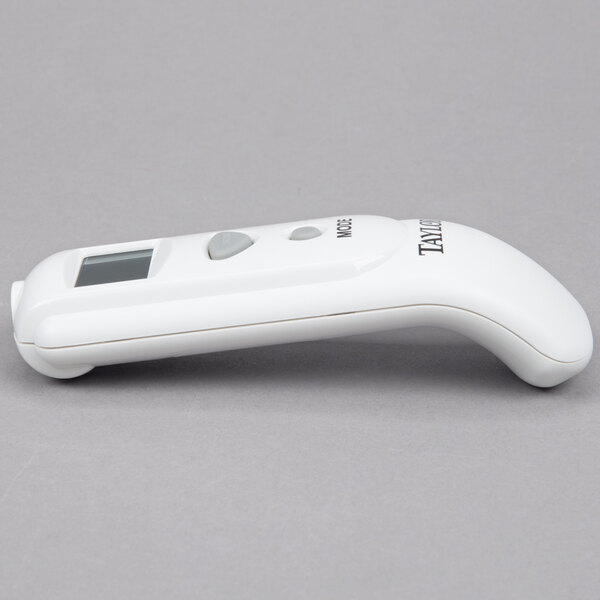 A white Taylor digital infrared thermometer with buttons.