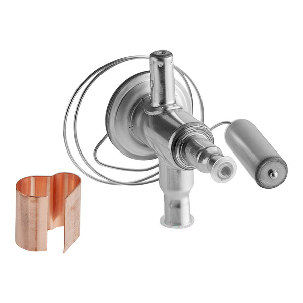 A close-up of a Manitowoc Ice expansion valve with copper tubes and a copper cover.