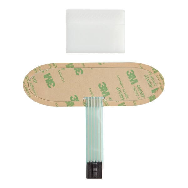 An oval-shaped adhesive membrane switch with a flat ribbon cable and connector, shown with a separate white rectangular component above it.