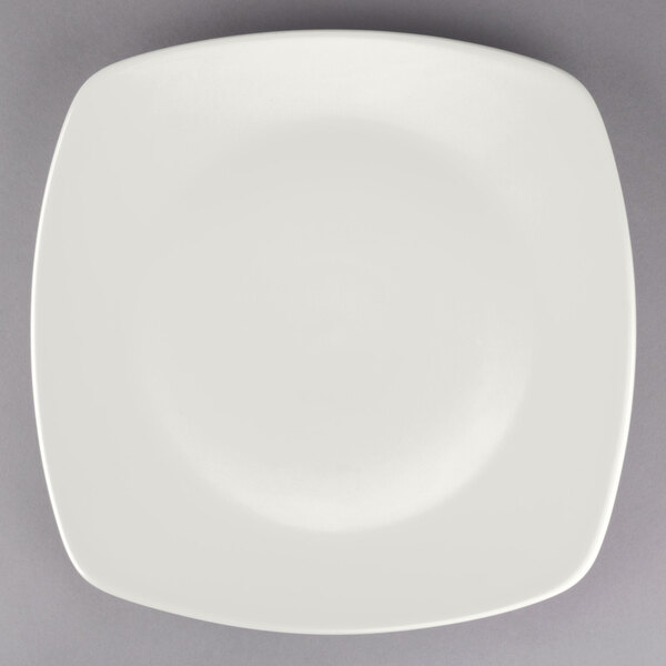 A Tuxton square china plate with a white rim on a gray background.