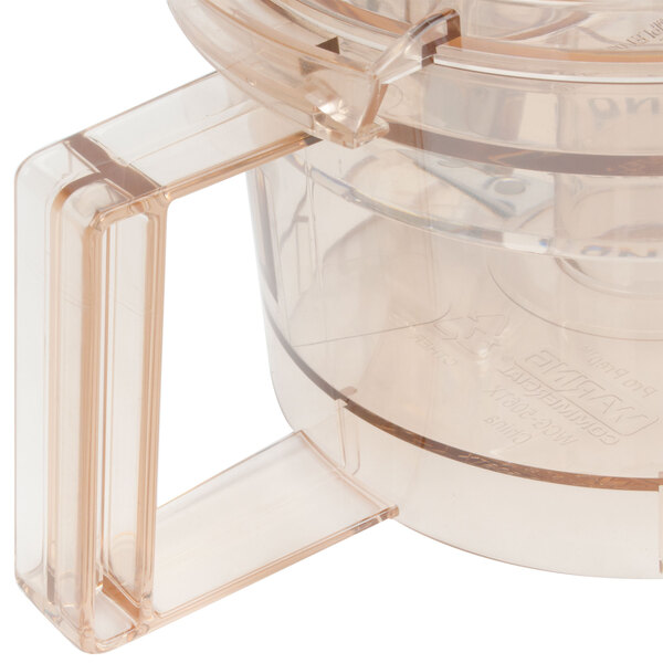 A clear plastic Waring grinding bowl with a clear plastic lid.