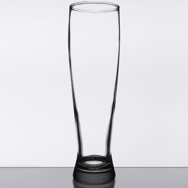 A clear Libbey pilsner glass on a table.