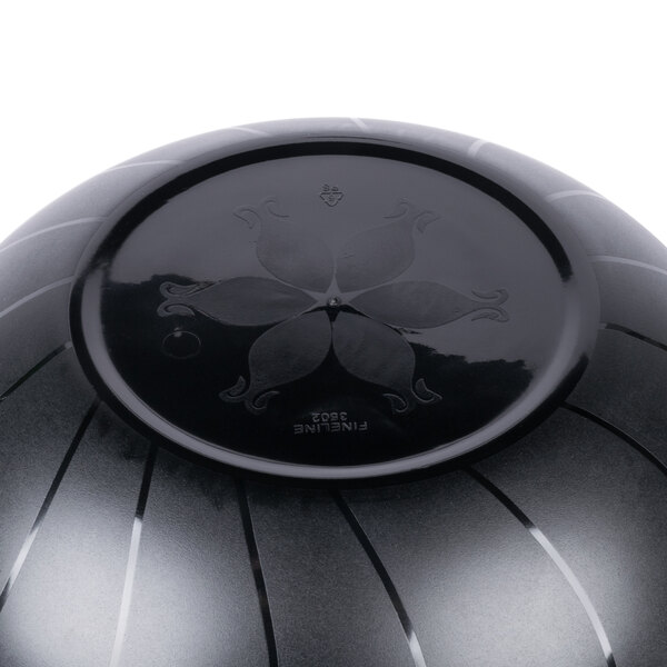 A black Fineline plastic bowl with a flower design on it.