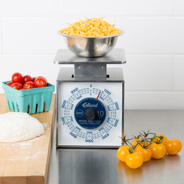 An Edlund portion scale with a bowl of tomatoes and cheese on it.