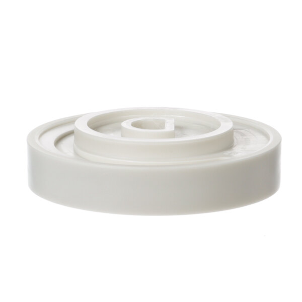 A white plastic wheel with a circular hole.