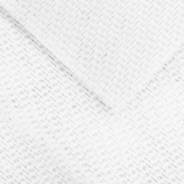A close-up view of a white, textured, nonwoven fabric with a subtle pattern.